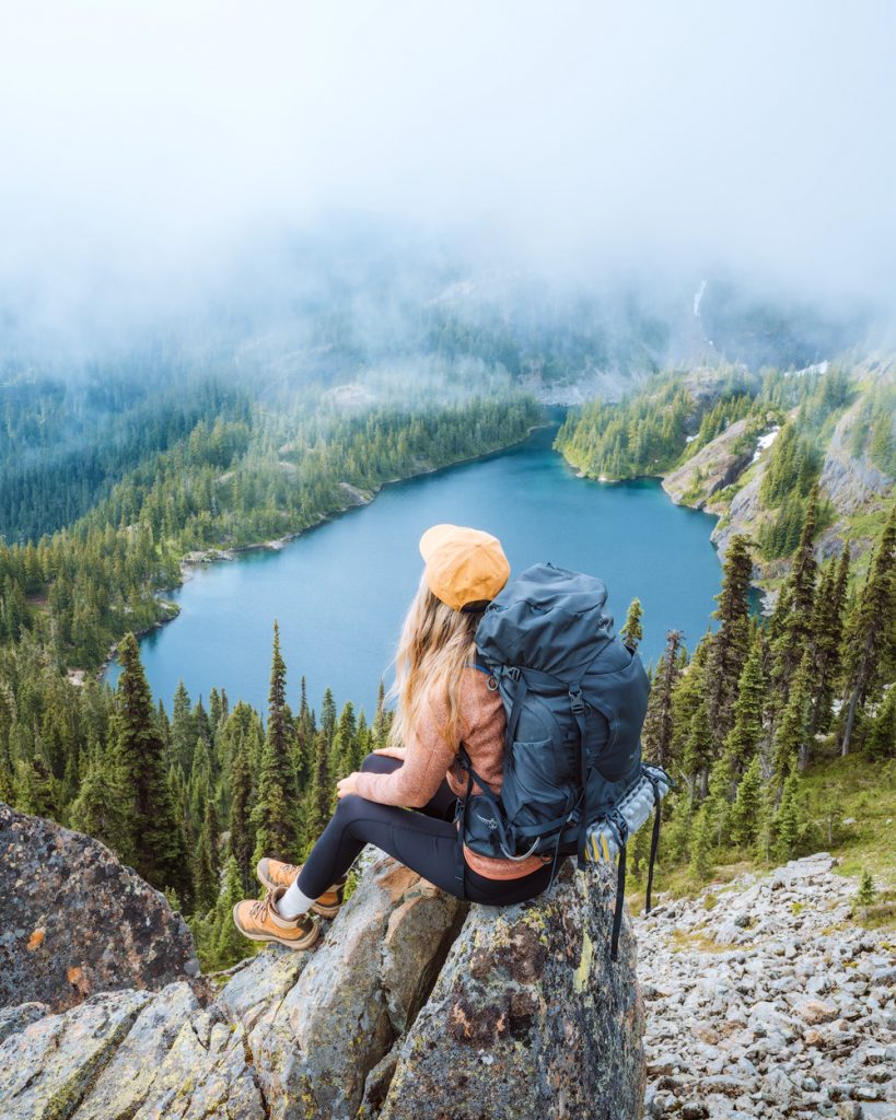 Female Backpacker Walking Away Along Earth Road Leading Through Forest  Stock Photo